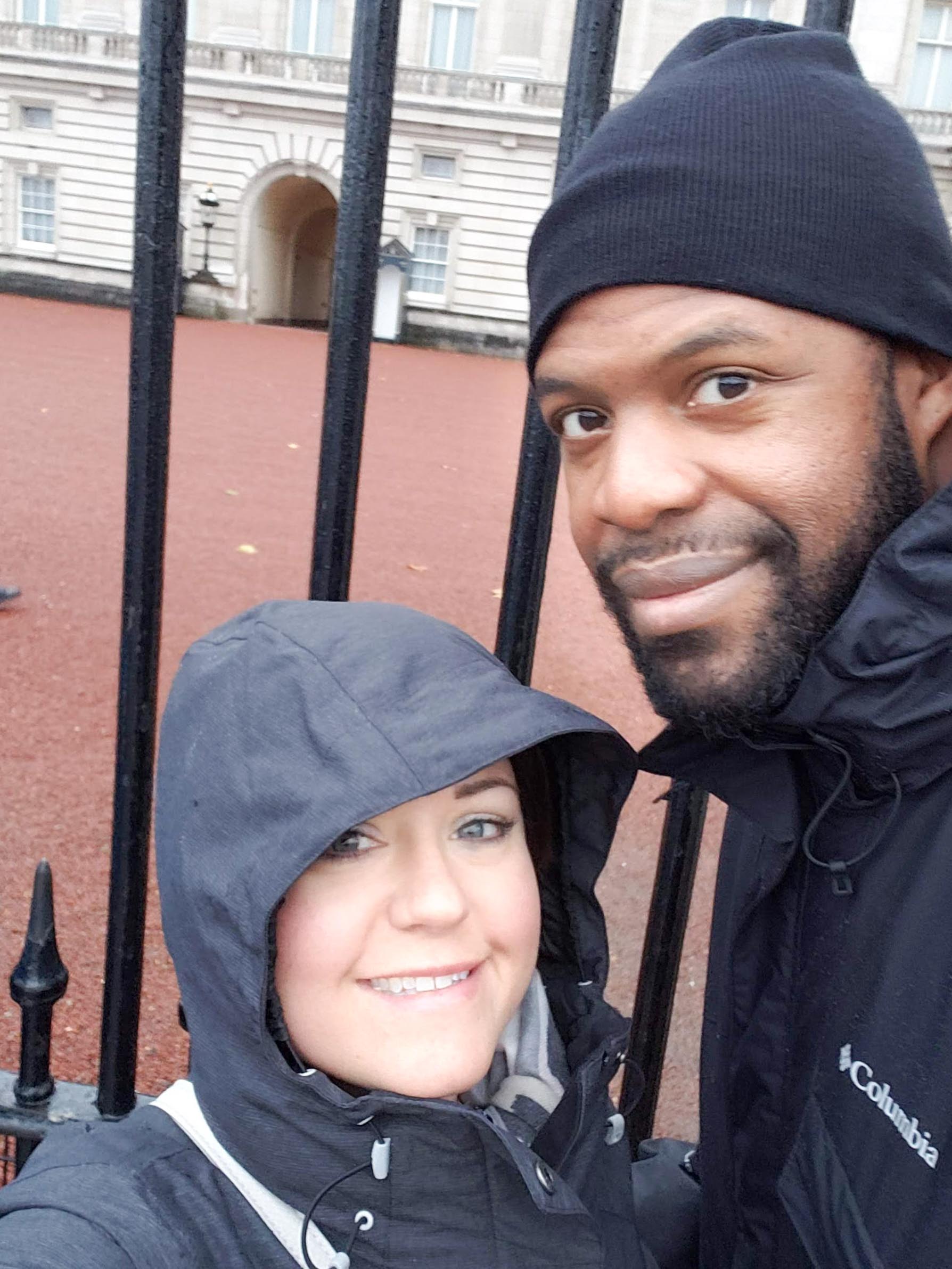 Jill and Desmond lean in for a photo outside buckingham palace gates