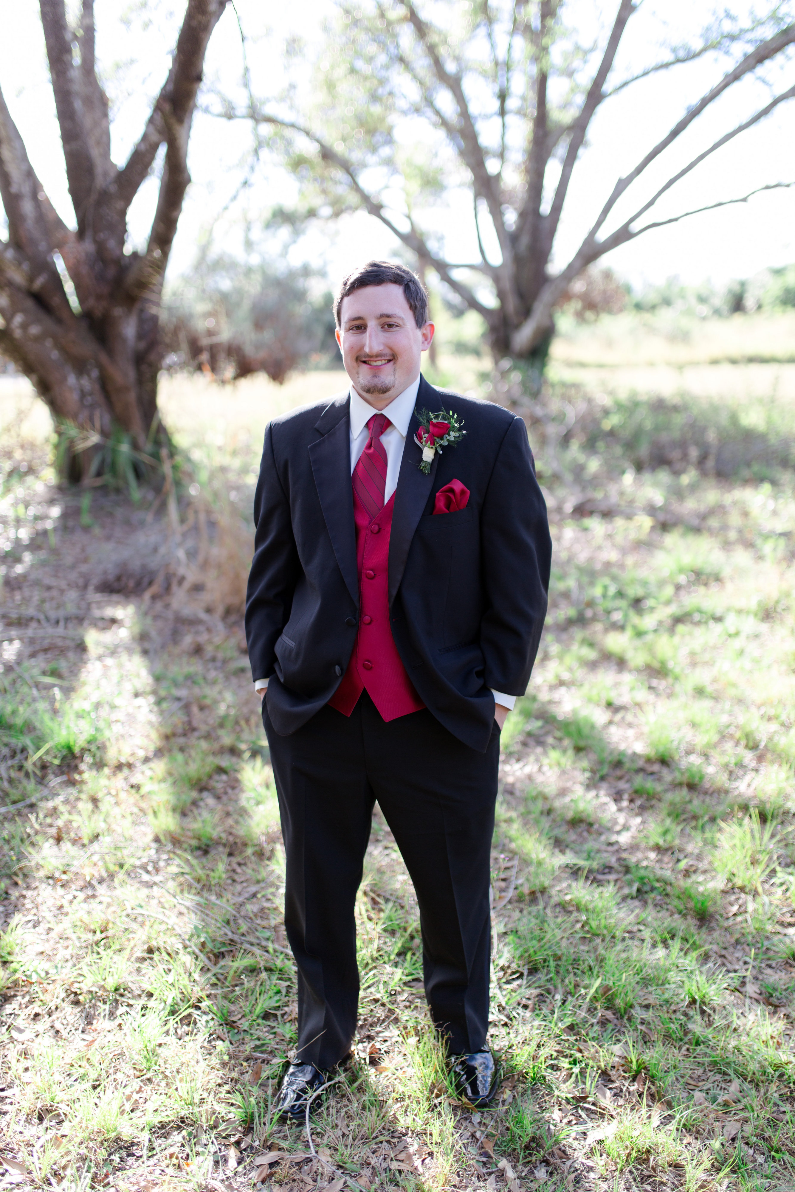 Red Rose, Boutonniere, Tuxedo, Red Vest, Hands in pockets, Groom poses, Groom, Groom photo ideas,  Wedding, Wedding Ring, Red, Married, Wedding Dress, Ft. Meyers, Florida