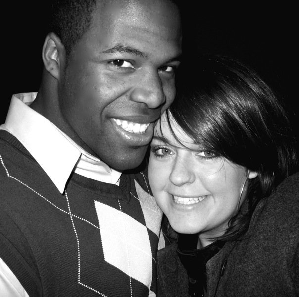 Black and white photo of interracial couple hugging